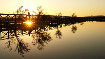 Puesta de sol en un puente de madera dentro de la Laguna de Fuente de Piedra en M&aacute;laga

