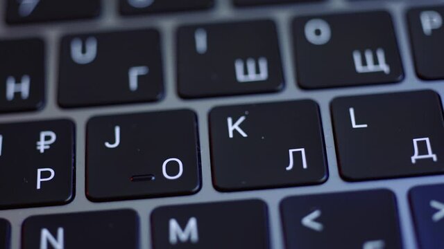 Close up of the keyboard of a laptop in black and white colors. Action. Concept of modern computer technologies, laptop keypad with glowing letters.