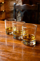 Flight of Scottish whisky, tasting glasses with variety of single malts or blended whiskey spirits on distillery tour in pub in Scotland