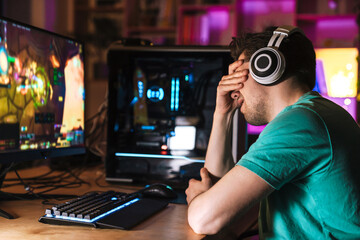 Image of unhappy young man crying while playing video game