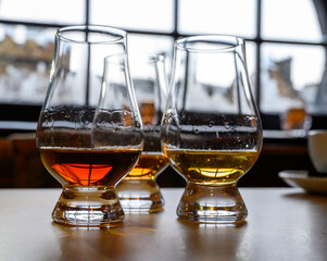 Flight of Scottish whisky, tasting glasses with variety of single malts or blended whiskey spirits on distillery tour in Scotland