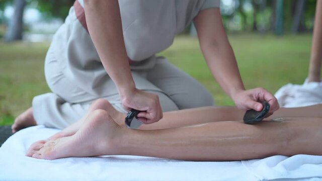 Cropped image of female leg receives massage spa