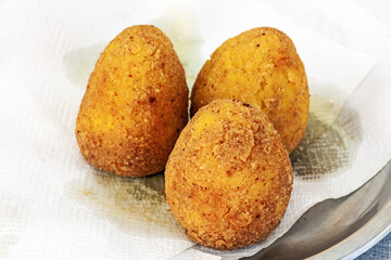 hot palatable arancini on the paper napkin. Sicily street food. Selective focus