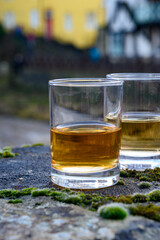 Scotch single malts or blended whisky spirits in glasses with old houses of Edinburgh on background, Scotland, UK