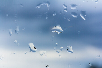 A small raindrop rests on the glass after rain.