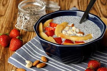 Bowl of chia poudding with pieces of apricots and strawberry