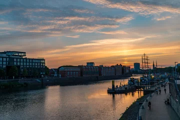 Sonnenuntergang im Sommer Landschaftsansicht blau orange Himmel in Europa Bremen Deutschland Tourismus Wahrzeichen Sightseeing in Schlachte Weser mit alten Vintage Boot Schiff mittelalterlich © Chan2545