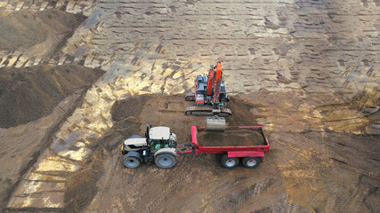 Baustelle: Tiefbau Erdbau Bauarbeiten: Bagger verlädt Erde, Sand auf einen Muldenkipper, Luftbild
