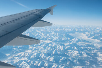 Fototapeta na wymiar Flying over the snowy mountains
