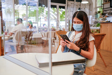 Woman asia in restaurant with social distancing protocol and lockdown city due to coronavirus pandemic