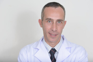 Portrait of mature handsome man doctor against white background