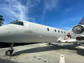 Obraz premium A man near a white plane. Blue sky. Journeys.