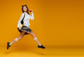 Fototapeta na wymiar Full length portrait of a cheerful schoolgirl in uniform