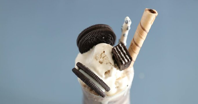Decorating parfait with Oreo cookies and ice cream and biscuits