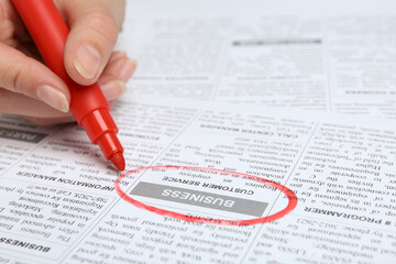 Woman marking advertisement in newspaper, closeup. Job search concept