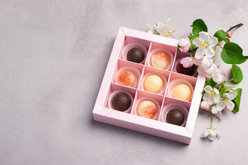 Chocolate candies in a festive box on a gray background. Holiday concept. Minimalism food dessert. Horizontal frame