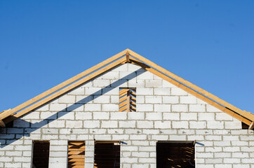 view of the unfinished gas-block house with a wooden roof. construction of houses