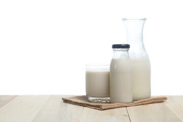 Milk in glass and in jar on table isolated on white background
