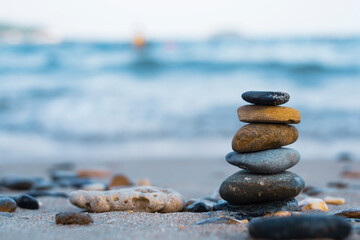 Pebbles are piled on a volcanic rock by the sea. Zen concept. Copy space