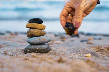 Pebbles are piled on a volcanic rock by the sea. Zen concept. Copy space