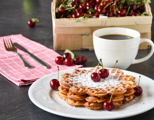 Waffeln - frisch warm und rund mit Kirschen Dekoration und Korb mit Kirschen
