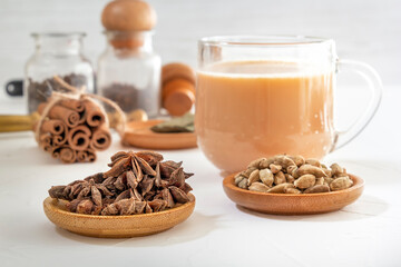 Star anise, cinnamon sticks, cardamom, bay leaf, pepper and other ingredients for making masala tea on a white wooden table