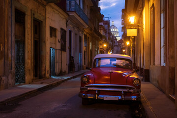Fototapeta na wymiar Amazing old american car on streets of Havana with Capitolio Building in background during night. Havana, Cuba.