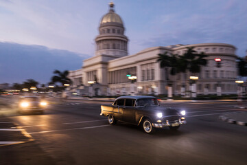 Old car on streets of Havana with Capitolio building in background. Cuba