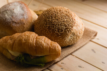 bread and wheat on white wood background with copy space