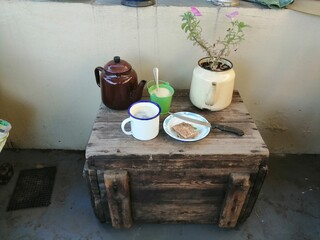 High Tea or Coffee in enamel and metal containers placed upon the old wooden box