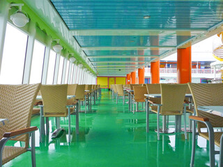 Sun loungers or deck chairs with tables on deck of classic cruiseship or cruise ship liner with...