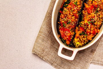 Karniyarik traditional Turkish food from stuffed eggplants with minced meat, tomato, greens and sesame seeds