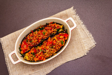 Karniyarik traditional Turkish food from stuffed eggplants with minced meat, tomato, greens and sesame seeds