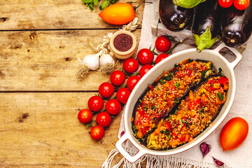 Karniyarik traditional Turkish food from stuffed eggplants with minced meat, tomato, greens and sesame seeds