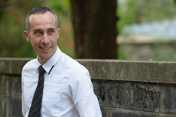 Portrait of happy mature handsome businessman outdoors