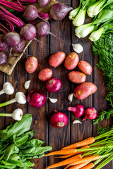 Carrot, potato, beet, onion and spinach on wooden background top view