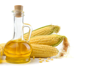 Corn oil in a carafe, peeled corn cobs and grain isolated on a white background