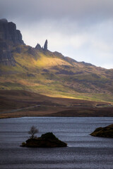 Naklejka na ściany i meble Loch Leathan and Old man of Storr rock formations, Isle of Skye, Scotland. Concept: typical Scottish landscape, tranquility and serenity, particular morphologies.