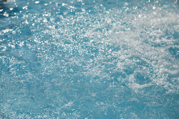 Splashes in swimming pool on sunny day. Summer vacation
