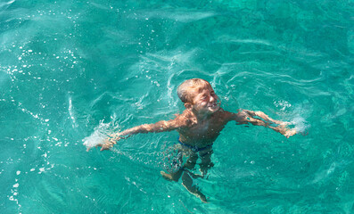 Top view at little kid swimming in the sea