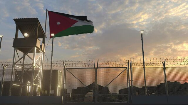 Waving flag of Jordan above military base in the evening