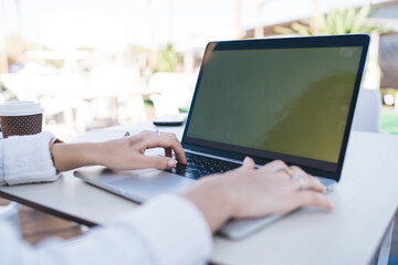 Selective focus on female hands typing program code during freelance job on modern laptop computer, cropped image of graphic designer creating web project during remote working on netbook technology