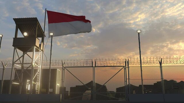 Flying flag of Indonesia above military base in the evening