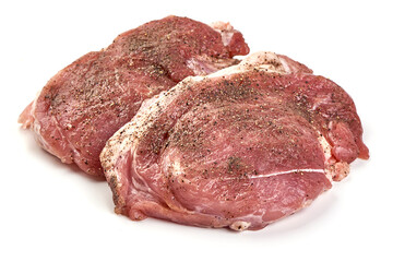 Raw pork steaks sprinkled with ground pepper, isolated on white background