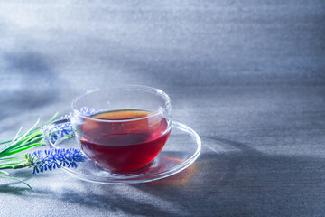 光が差し込む透明グラスに入った紅茶。癒し・休憩・カフェ・ティータイム