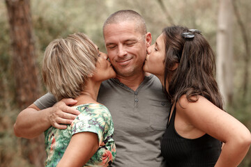 Uomo bianco veien baciato dalla propria moglie Brasiliana e dalla figlia misto Italo-Brasiliana dentro un parco