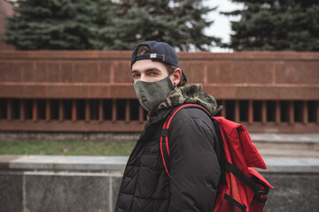 Street fashion male wearing face mask with red backback