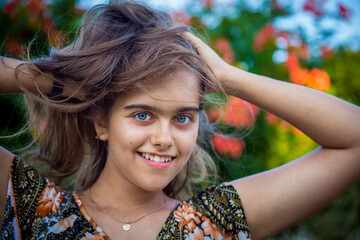 Naklejka premium Portrait of a beautiful smiling girl. Happy girl in summer. Summer girl closeup. Smiling girl with long hair