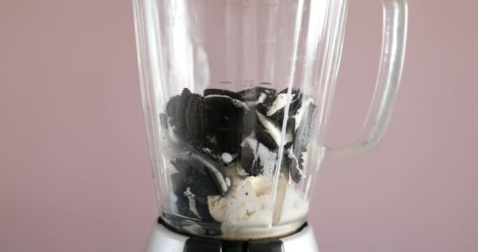 Mixing ice cream, cookies and milk together in blender
