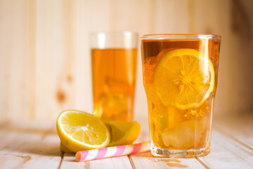 Glasses of ice tea with lemon slices  on wooden background